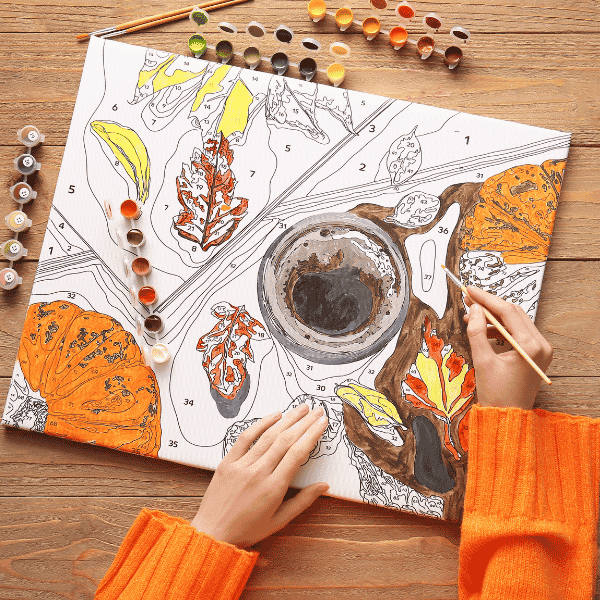 person painting a leaves and coffee cup paint by number painting